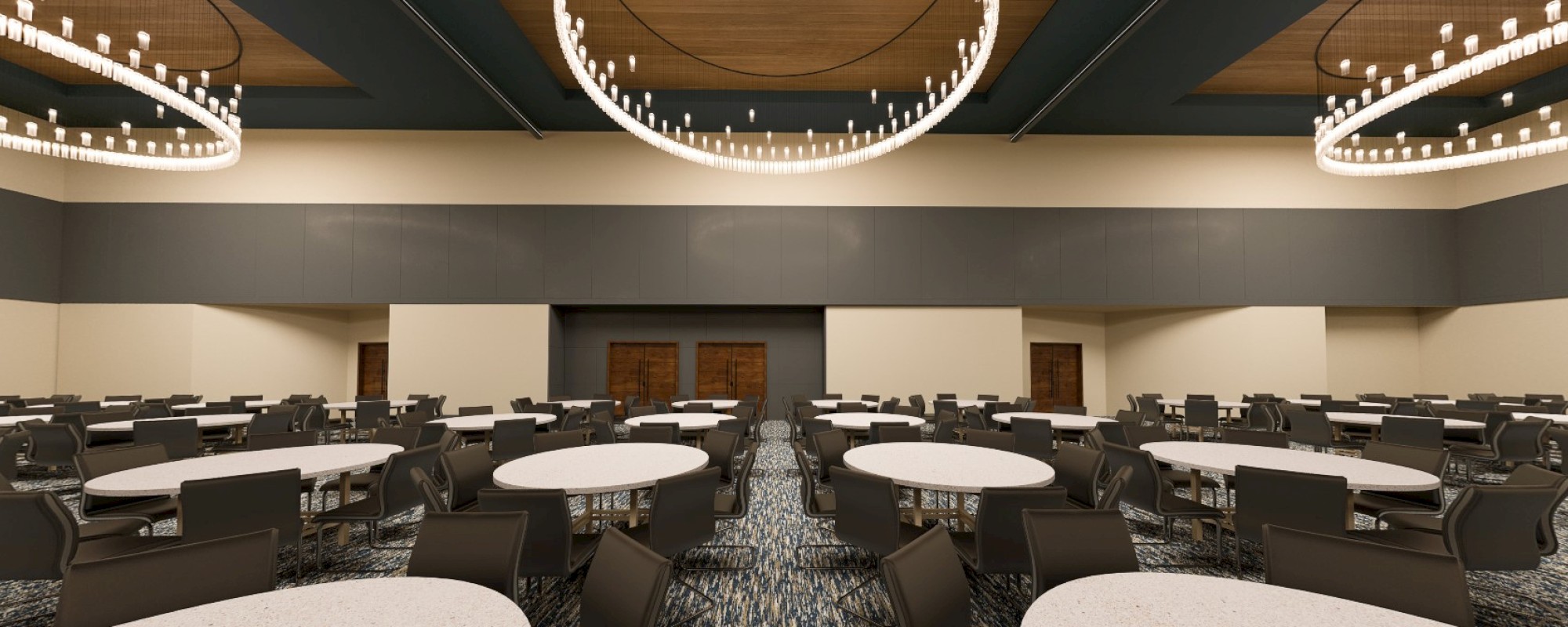 The image depicts a large, modern conference room with round tables, chairs, and elegant circular chandeliers hanging from the ceiling.