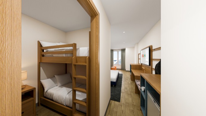 The image shows a hallway with a bunk bed on the left and a path leading to a bedroom with a bed, desk, and other furniture in a modern hotel room.